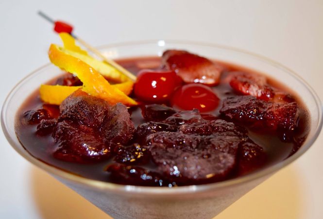 Vermouth cocktail with maraschino cherries and orange twist